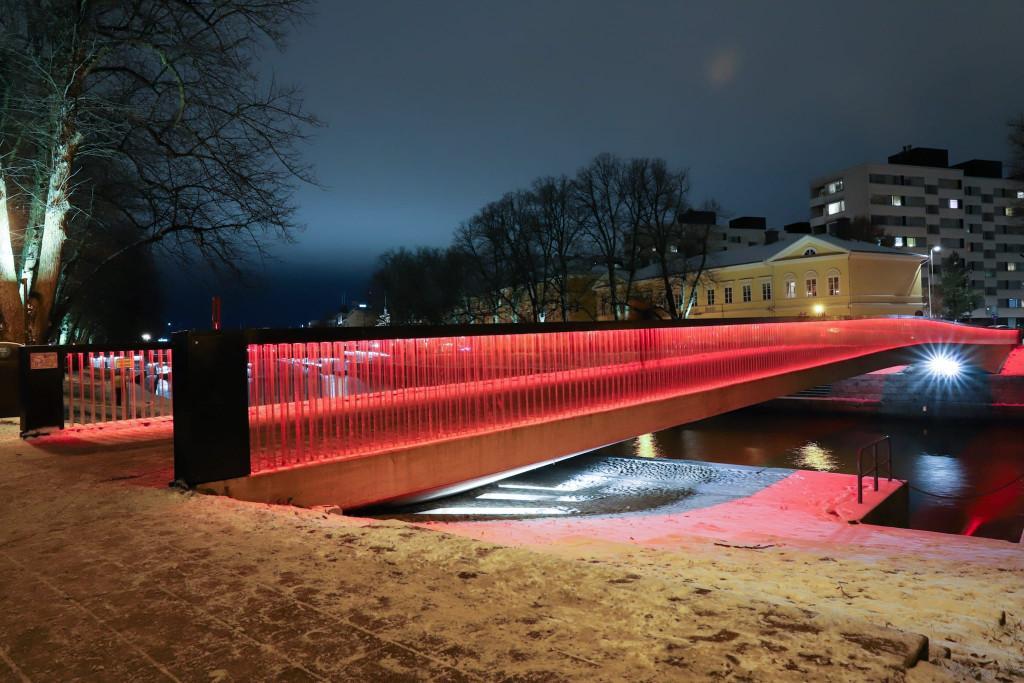 Kuvassa Turun Kirjastosilta valaistuna punaiseksi pimeässä marraskuun illassa.