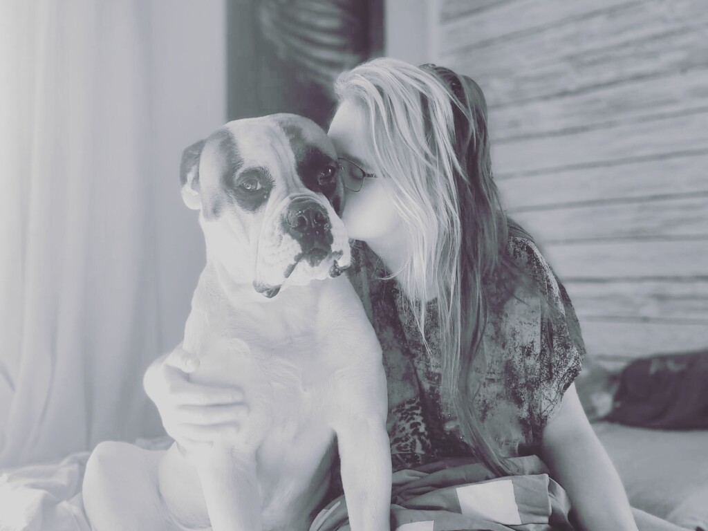Mustavalkoinen kuva, jossa ovat Maiju Moilanen ja hänen koiransa.